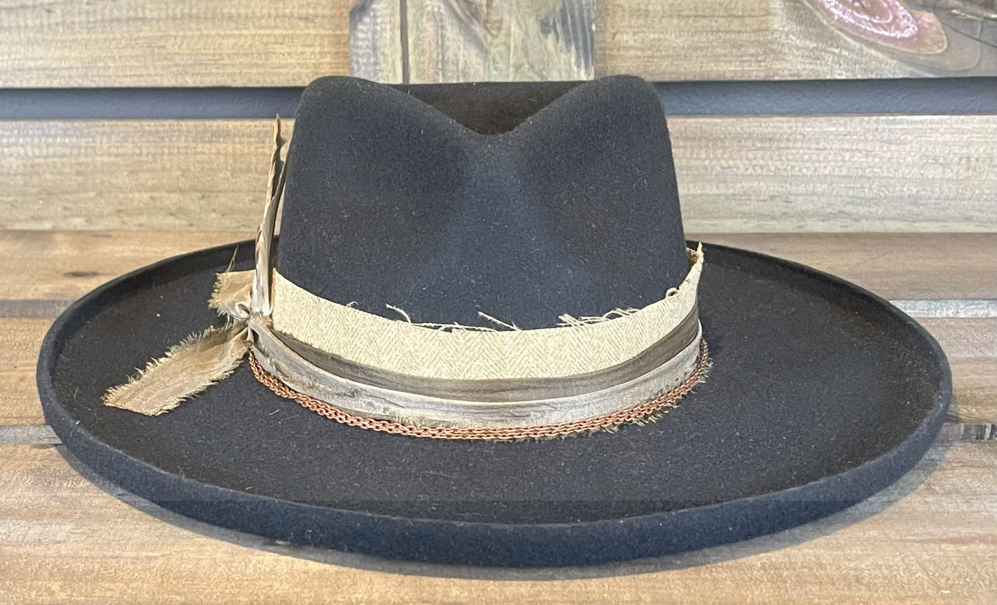 A wide pencil brim by American Hat Makers. Layered with multiple bands and a double wrapped copper chain. Styled with unique feathers.