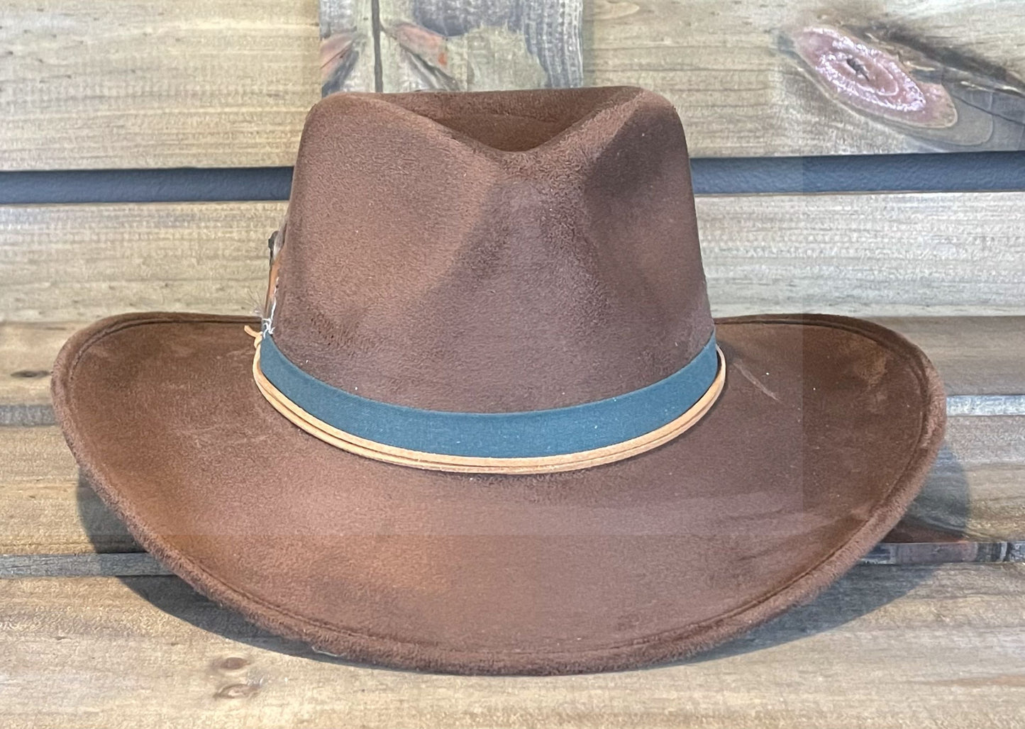 A chocolate brown vegan suede hat simply styled with a band and a few pheasant feathers.