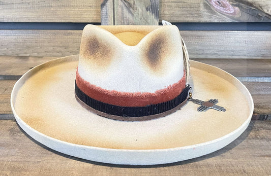 Peter Grimm hat with a wide pencil brim. Burned and styled with a large feather and a iron Zia charm.
