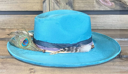 A Turquoise funky and fun vegan suede hat wrapped with recycled silk and suede strings. Styled with Peacock feathers.