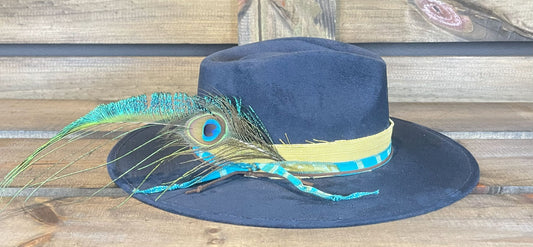 The Beckville is a navy blue flat brim vegan suede hat styled with Peacock feathers. 