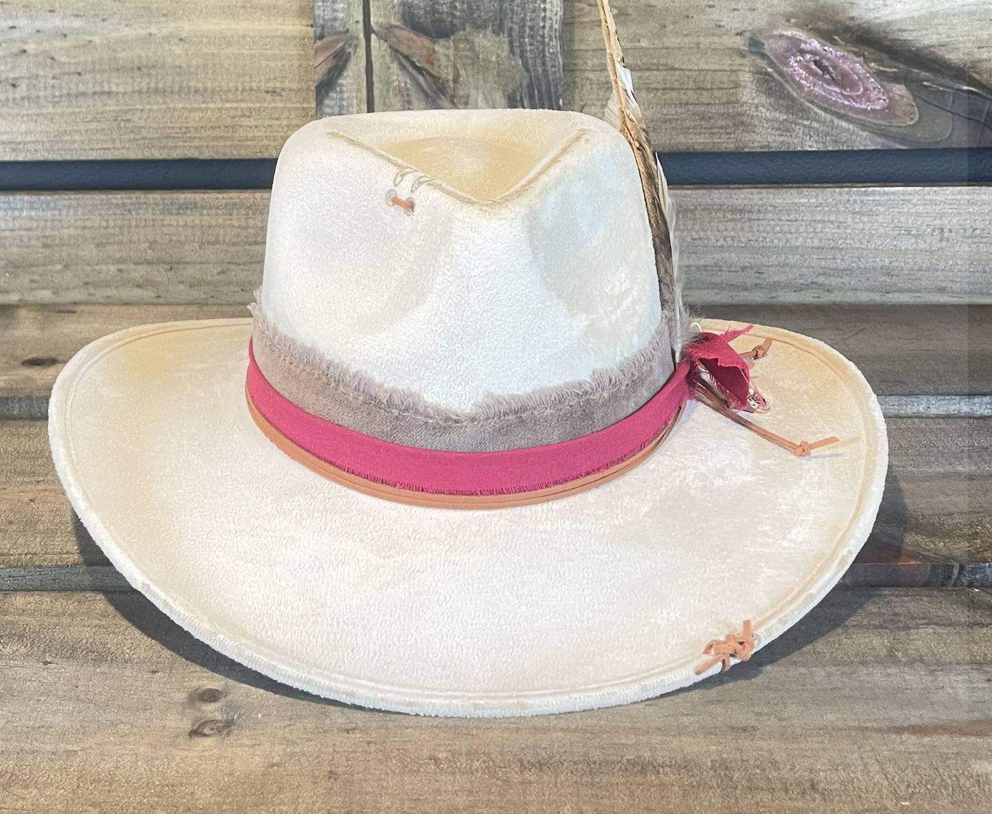 The Waller is a vegan suede hat burned and stitched. Layered with a frayed band and styled with a cluster of feathers.