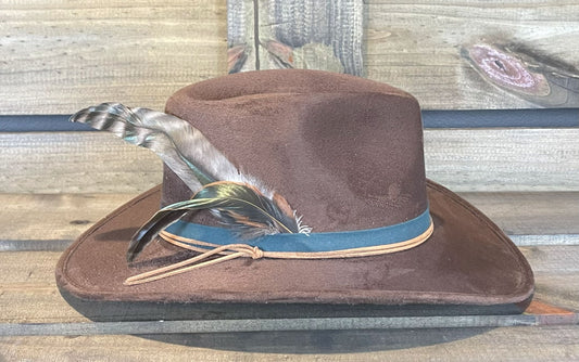 A vegan suede hat simply styled with a band and a few pheasant feathers.